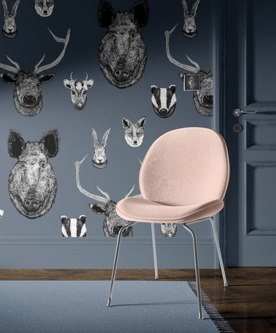 A section of wallpaper featuring hand-drawn black and white illustrations of British animals such as a deer, boar, badger, fox, and rabbit against a deep blue background.