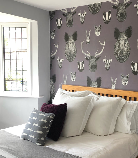 Grey British wildlife wallpaper used in a neutral bedroom or hallway with heritage animal illustrations