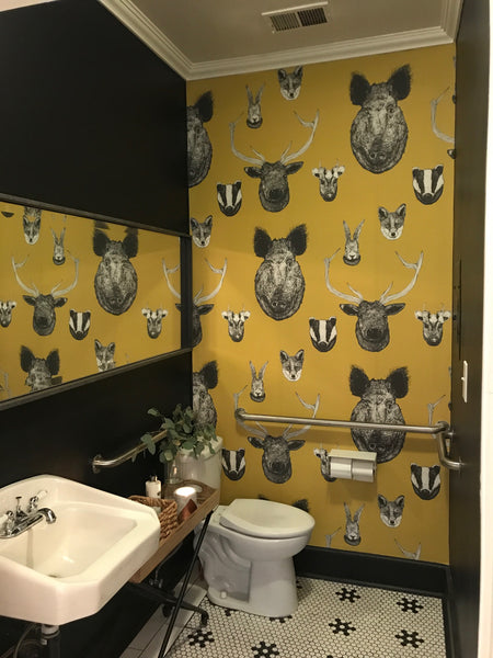 Mustard animal wallpaper used in a warm country house interior with British wildlife and heritage styling