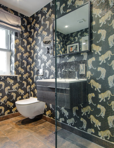 Charcoal leopard print wallpaper pattern with hand-painted prowling leopards on a dark tonal animal skin background