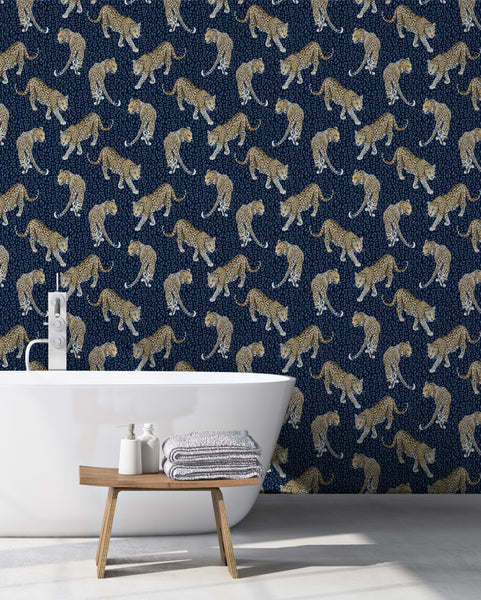 Blue leopard wallpaper used in a bathroom with freestanding white bath, wooden stool and bold animal print wall